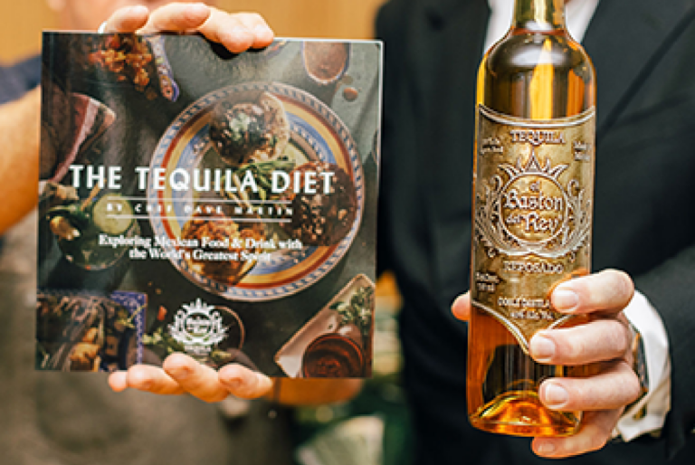 persona sosteniendo una botella de tequila y un recetario Almacén Guadalajara